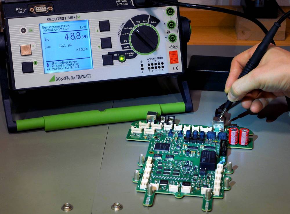 Elektroniker misst den Berührungsstrom an einem berühbaren Teil mit dem Sicherheitsprüfgerät Gossen Metrawatt Secutes SIII+|M