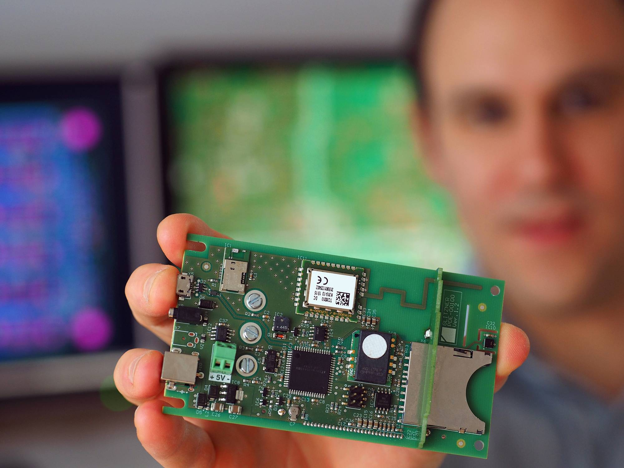 Elektroniker zeigt Leiterplatte